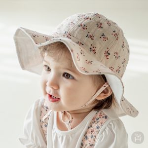 Image showcasing a baby wearing the Hella Reversible Baby Sun Hat, highlighting its stylish and protective features. Available in multiple sizes at Tiny You Baby Store.