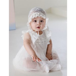 Photograph showing a baby girl dressed in the Lainie Baby Girl Bodysuit, focusing on the delicate lace details and soft fabric, perfect for special occasions