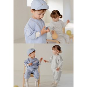 Adorable toddler in blue Onbie Baby Set-Up with apple embroidery, available at Tiny You Baby Store.