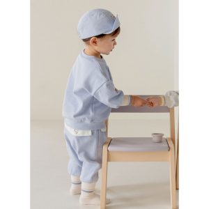 Adorable toddler in blue Onbie Baby Set-Up with apple embroidery, available at Tiny You Baby Store.