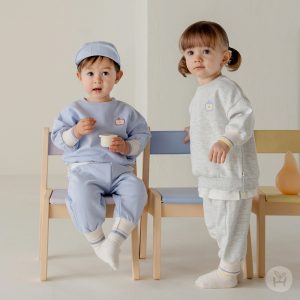 Adorable toddler in blue Onbie Baby Set-Up with apple embroidery, available at Tiny You Baby Store.