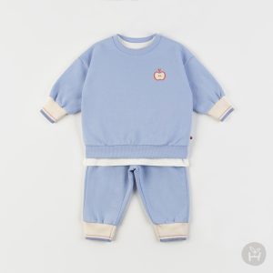 Adorable toddler in blue Onbie Baby Set-Up with apple embroidery, available at Tiny You Baby Store.