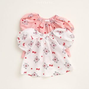 Cute toddler blouse in ivory and pink with playful rabbit patterns and puff sleeves, designed for comfort and style, part of OOTTBEBE's summer collection.