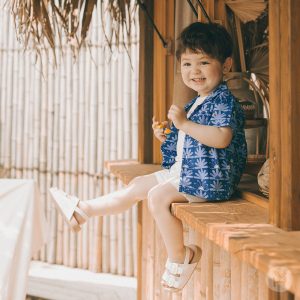 Showcasing the Spica Baby Set-Up with its tropical blue patterns, positioned against a serene beach backdrop. Ideal for fashionable summer days