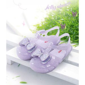 Children's Purple Ribbon Jelly Shoes displayed on a wooden bench outdoors, featuring sparkling ribbons and breathable material, ideal for summer play and rain