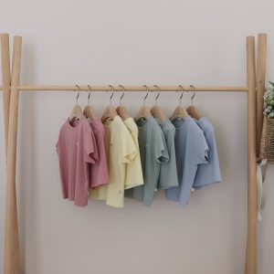 Yellow short-sleeve top and shorts set from Here I Am Pleated Two Piece Collection, hanging on a wooden rack.